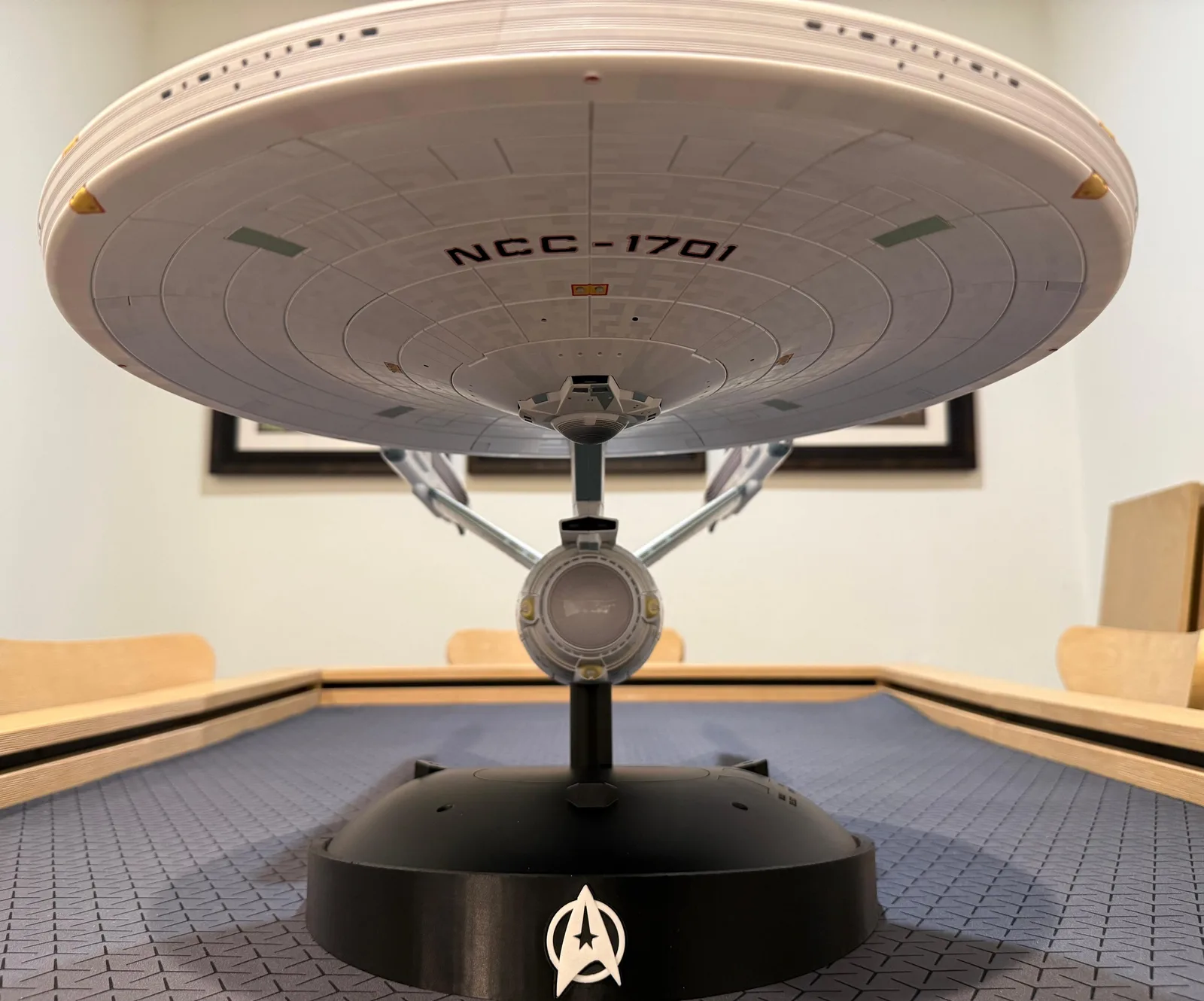 A TOMY 1/350 Enterprise Refit displayed level on the base, registry markings visible along the saucer.