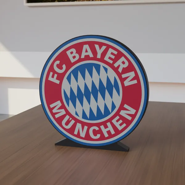 Freestanding 3D-printed logo sign, front view, 300mm size, standing on a wooden table.