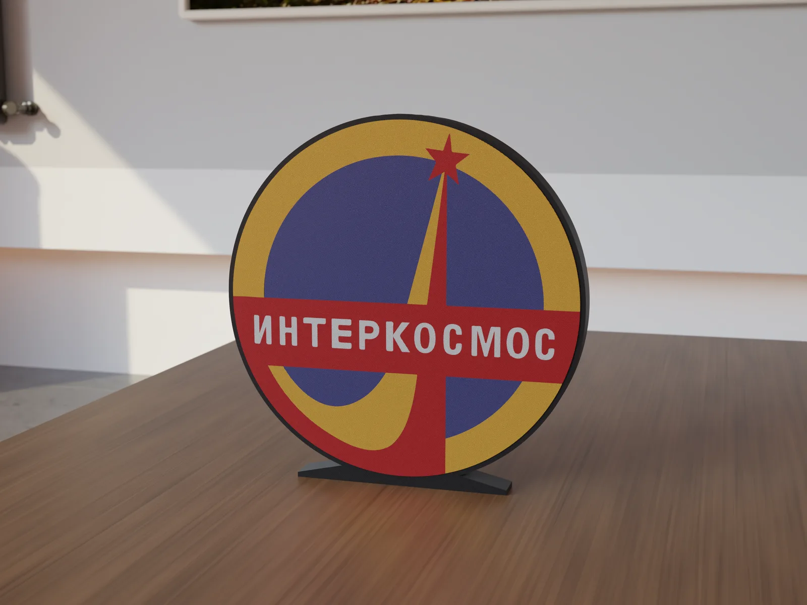 Freestanding 3D-printed logo sign, front view, 300mm size, standing on a wooden table.