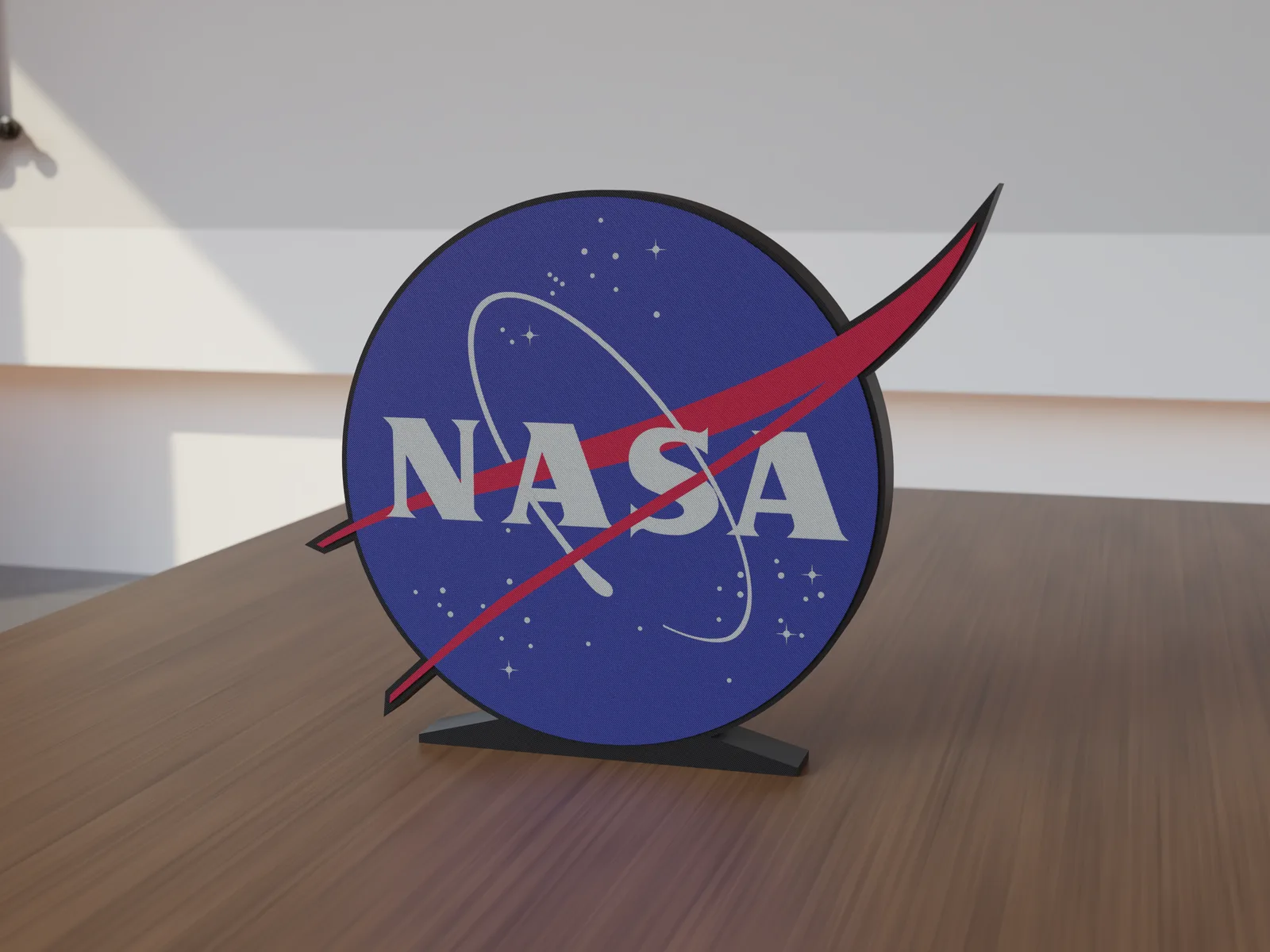 Freestanding 3D-printed logo sign, front view, 300mm size, standing on a wooden table.