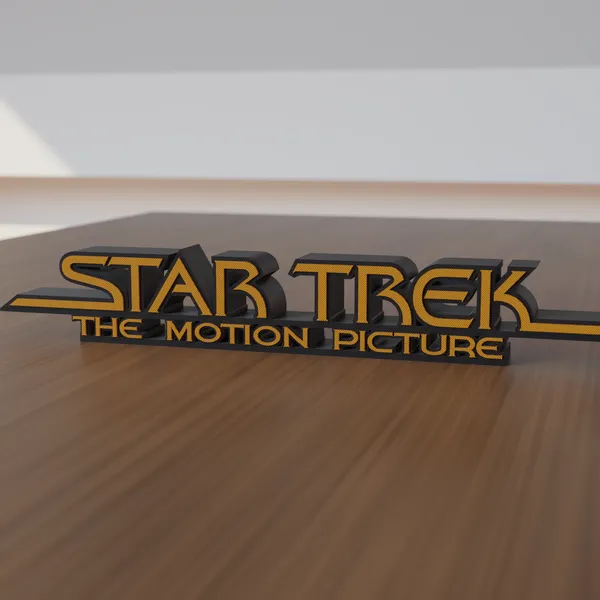 Freestanding 3D-printed logo sign, front view, orange lettering on a black body, 300mm size, standing on a wooden table.