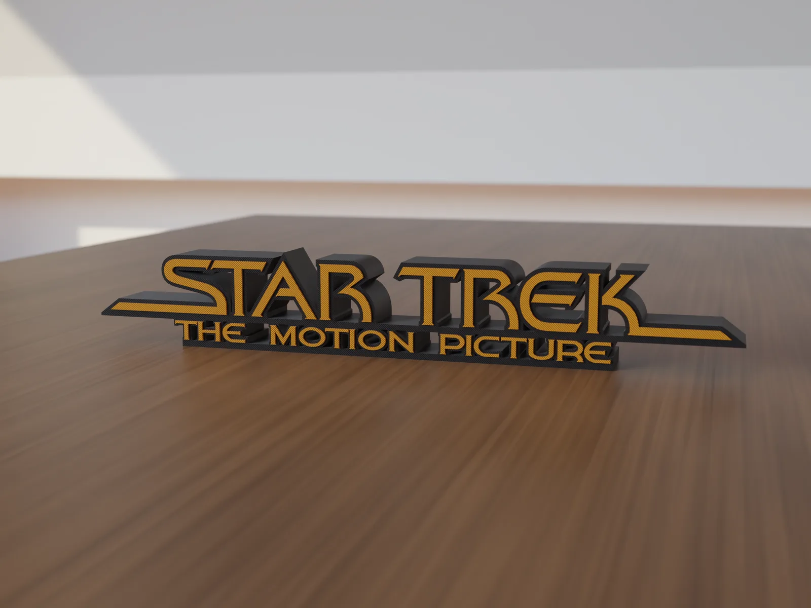 Freestanding 3D-printed logo sign, front view, orange lettering on a black body, 300mm size, standing on a wooden table.
