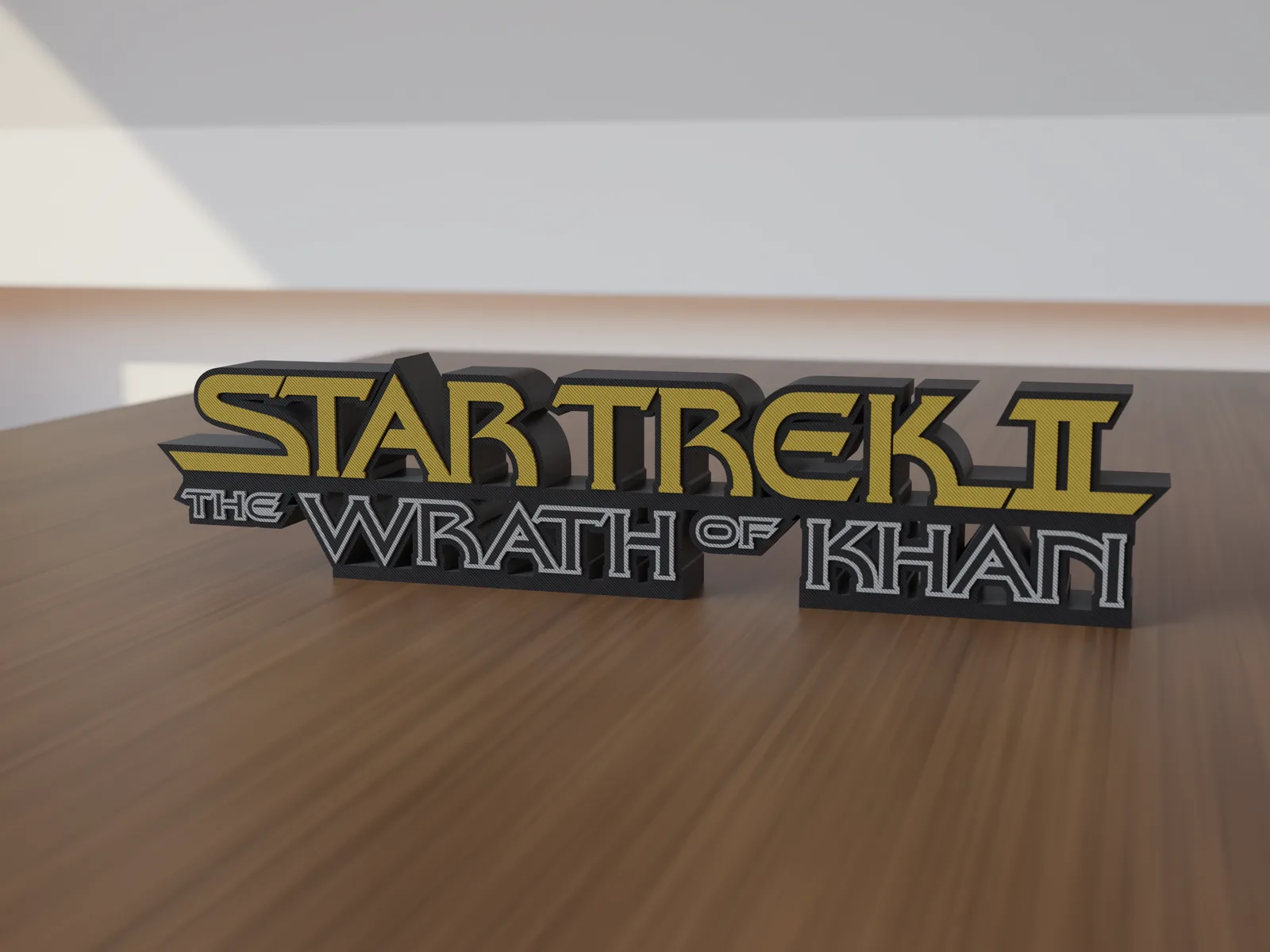 Freestanding 3D-printed logo sign, front view, Black Face style with gold upper line and gray-outlined black letters below, 300mm size, standing on a wooden table.